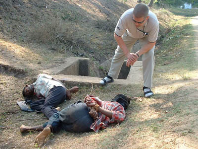 An international truce monitor examines the bodies of two youth abducted in the Sri Lanka Army-controlled area. Photo TamilNet