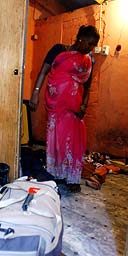 A Sri Lankan Tamil woman packs her bags after being evicted from her low-budget hostel in Colombo