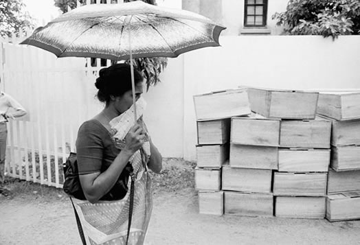 Colombo , 1987: A woman passes stacks of coffins outside a morgue. They are victims of a car bomb which killed 111 people, with nearly 300 injuries